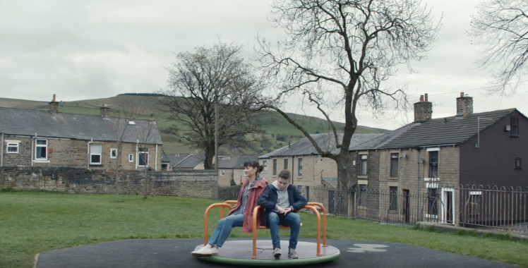 Still from advert, mother and son on roundabout