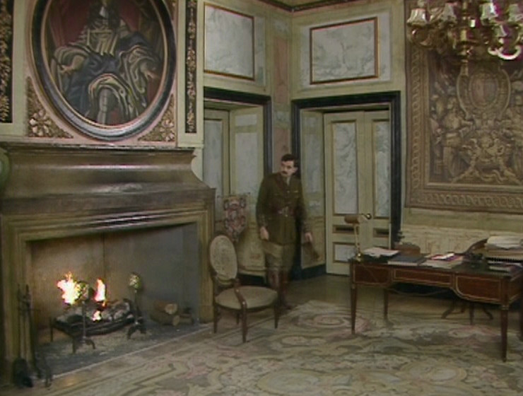 Blackadder in Melchett's office, with the circular portrait and the tapestry