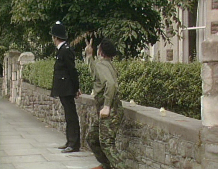 Rick flicking a V sign at a policeman