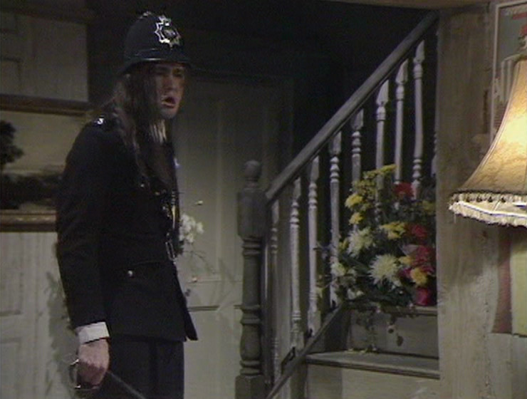 Neil as policeman in hall, from the broadcast episode