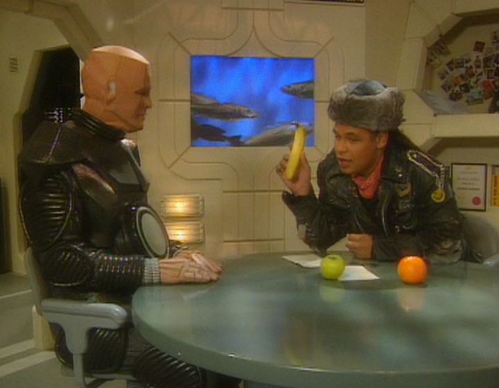 Kryten and Lister with the fish in the background