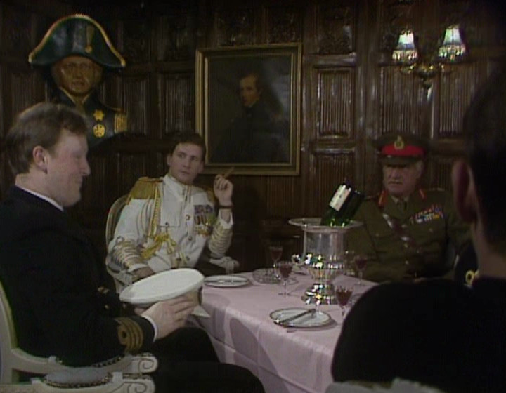 Rimmer at the Admiral's table, with the same wood panelling in the background