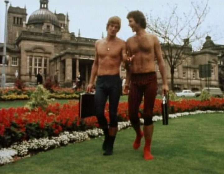 Two topless men walking together