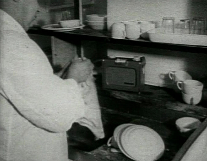 Man washing dishes with radio in background