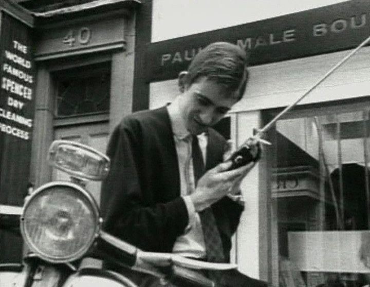 Young man listening to portable radio in the street