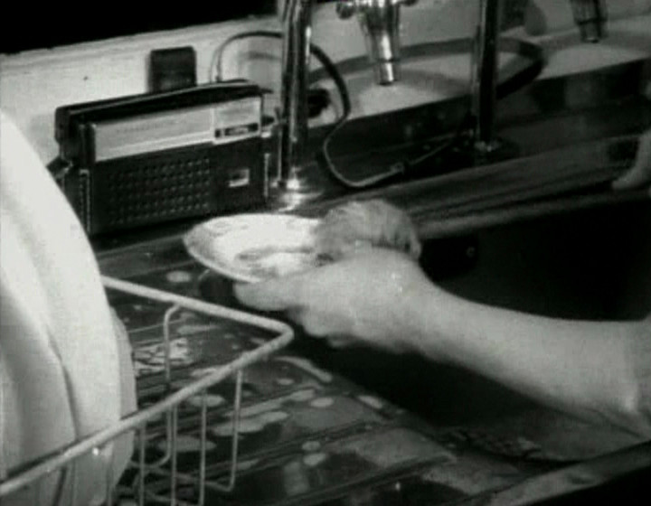 A different person washing dishes with radio in background