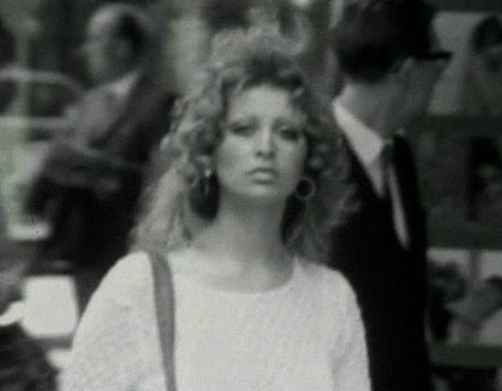 Black and white: woman with curly hair in street