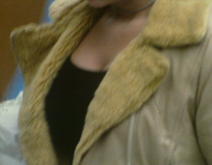 Close-up of woman's chest, wearing sheepskin coat or similar