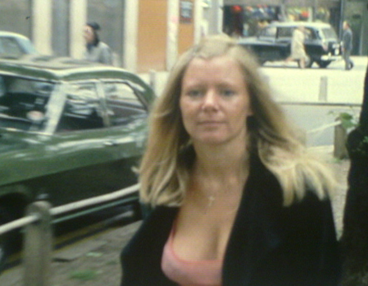 Woman with cleavage in street, looking at camera