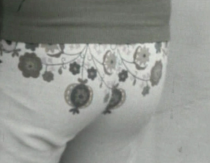 Black and white: close-up of a woman's bottom, wearing tight trousers