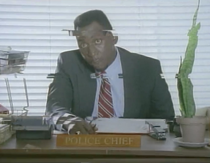 Colin McFarlane as the Police Chief, at his desk