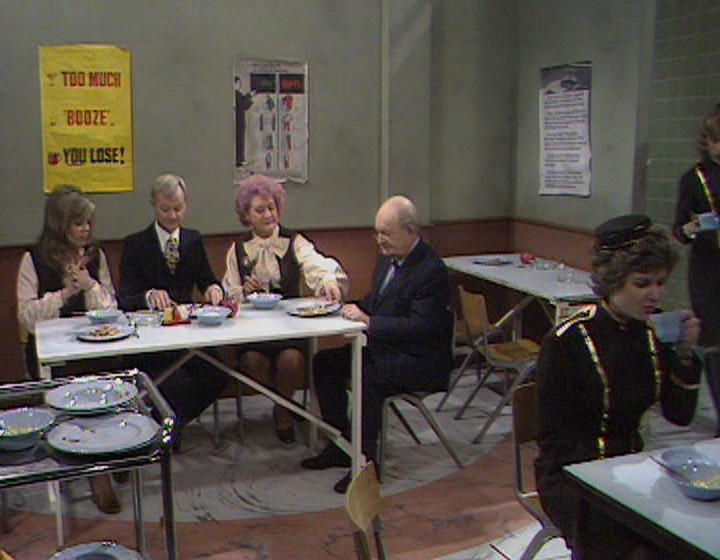 The Are You Being Served? gang around a table in the canteen, with a gap around one side